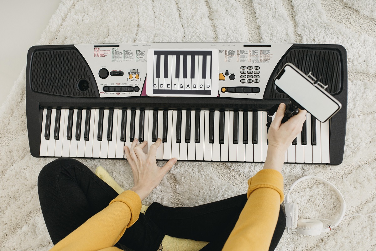 Vista de uma jovem tocando piano digital em casa Vista de uma jovem tocando piano digital em casa